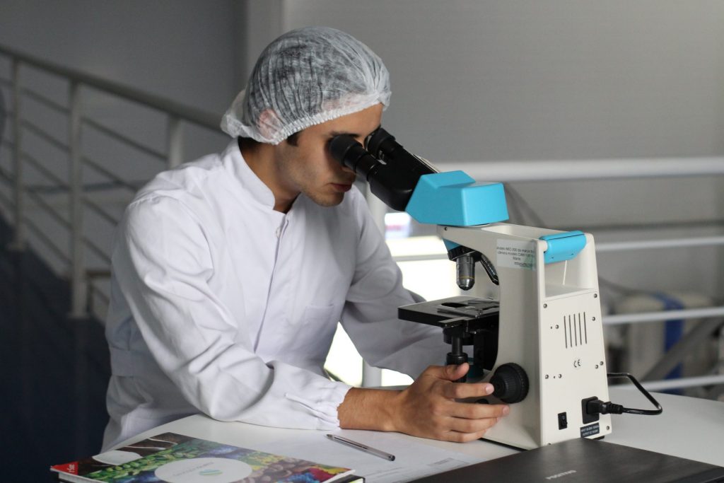Man looking into microscope in a lab