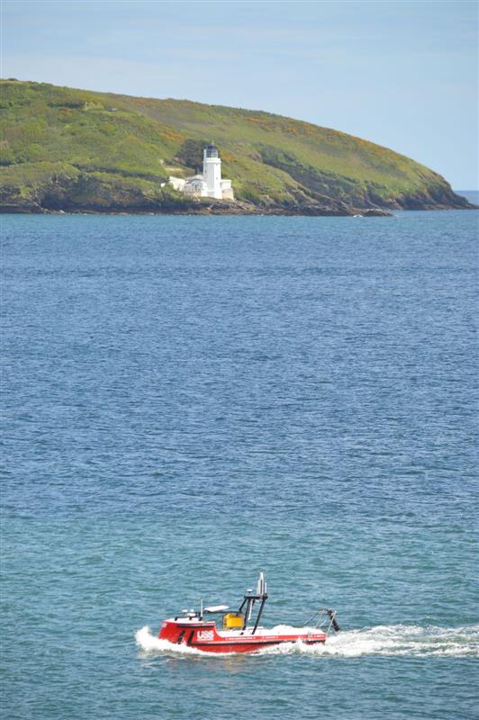 The unmanned Survey Vessel in front of St Anthonys Lighthouse