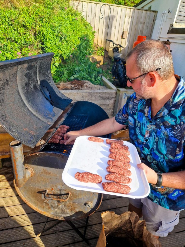Putting sausages on the barbecue